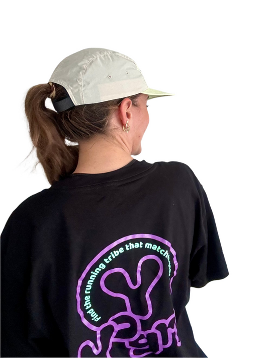 Person wearing a black t-shirt with purple and white text and graphics, standing against a plain background.