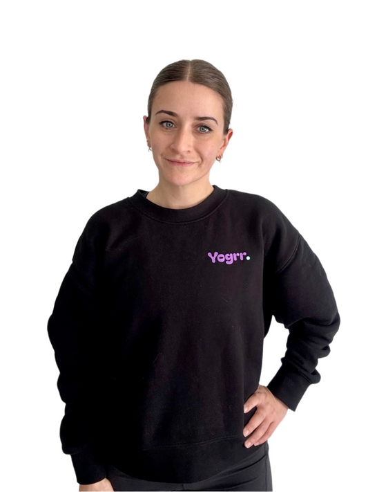Person wearing a black sweatshirt with 'Yogrr' text on a plain background