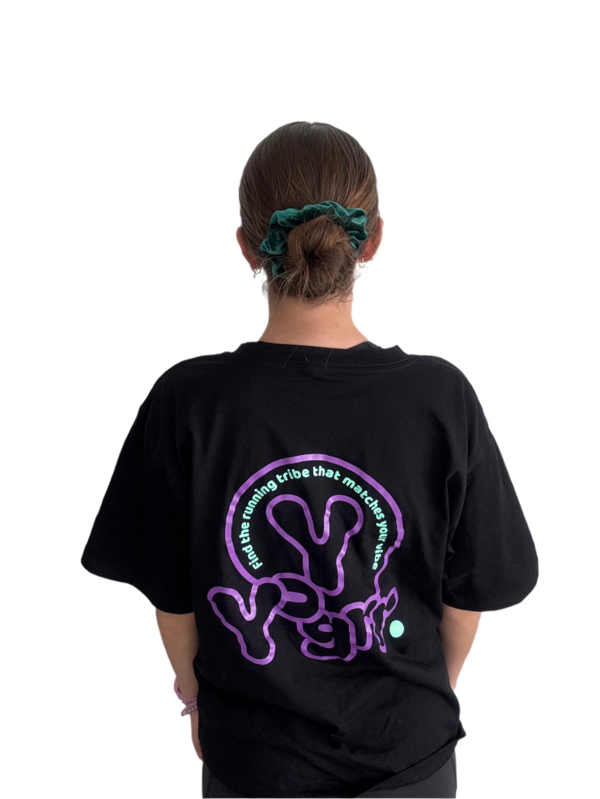 Person wearing a black t-shirt with a purple and green design on the back against a plain background