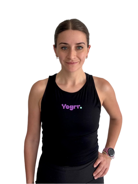 Woman wearing a black tank top with 'Yogrr.' text against a plain background